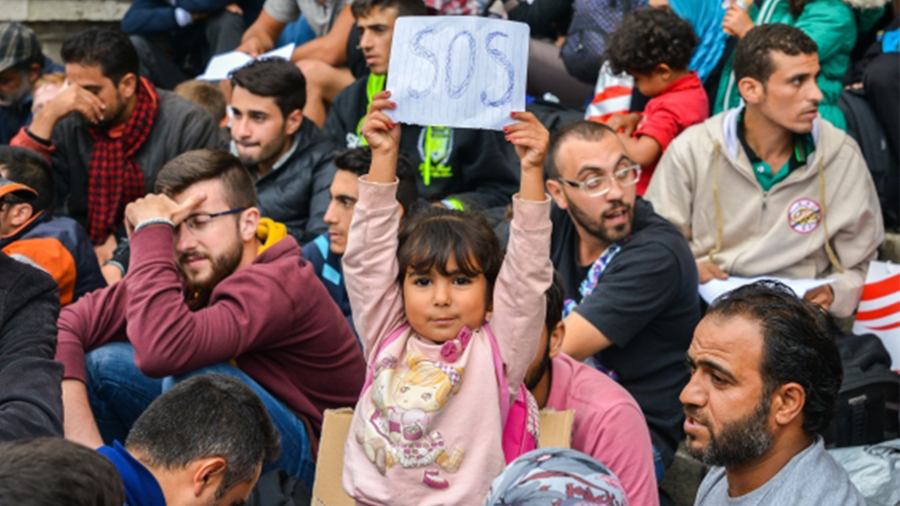 Child holding SOS banner