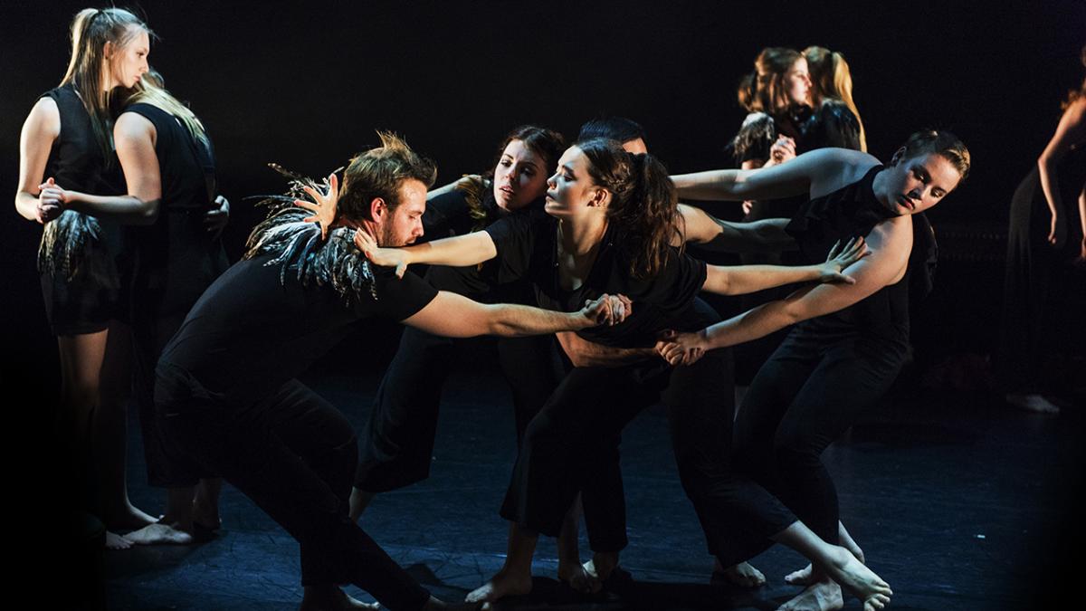 image of young people in black holding each other and dancing