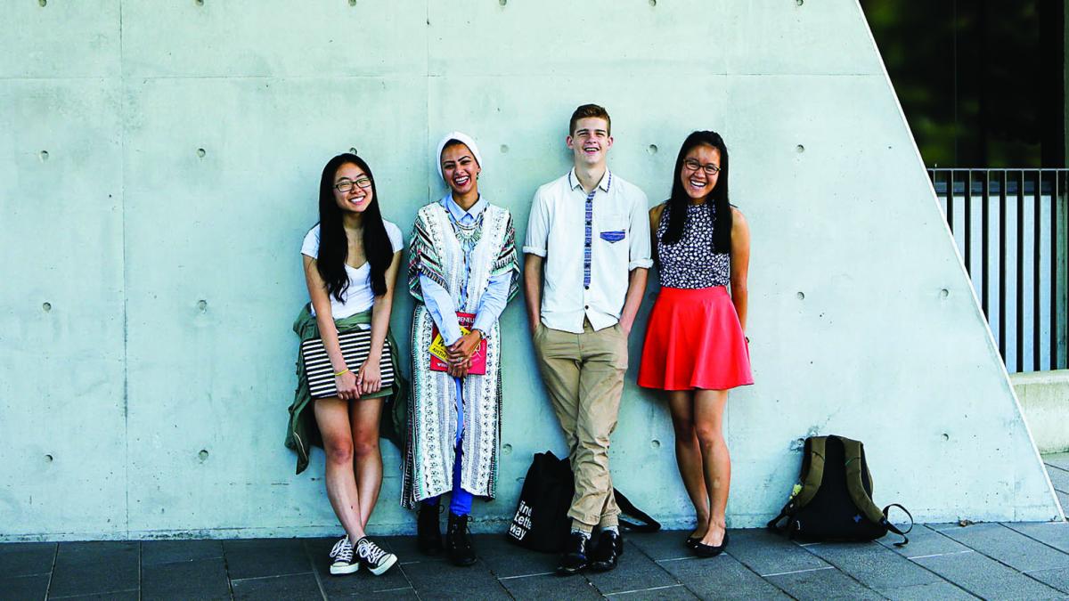 photo of students leaning in front of a wall