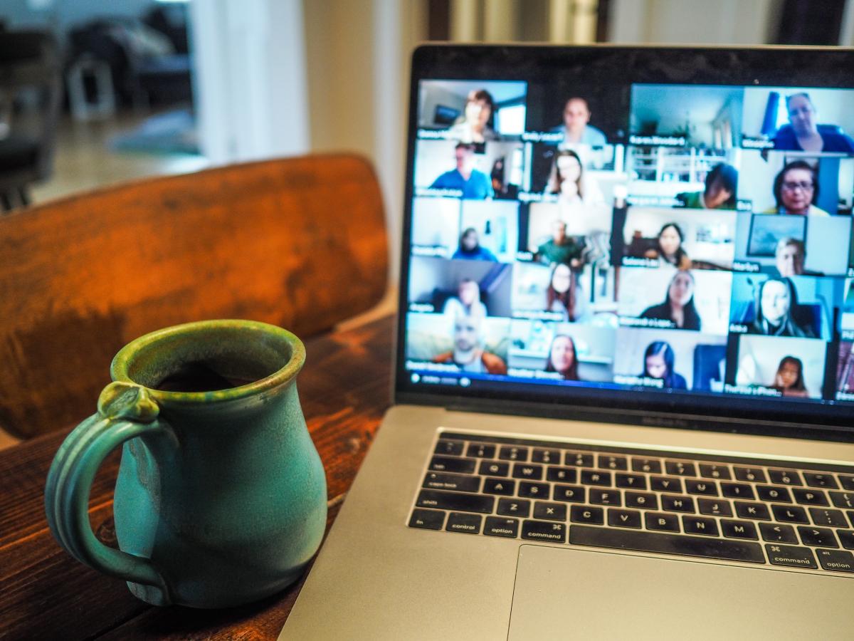 photo of a laptop on a table open to the group meeting, with a cup 