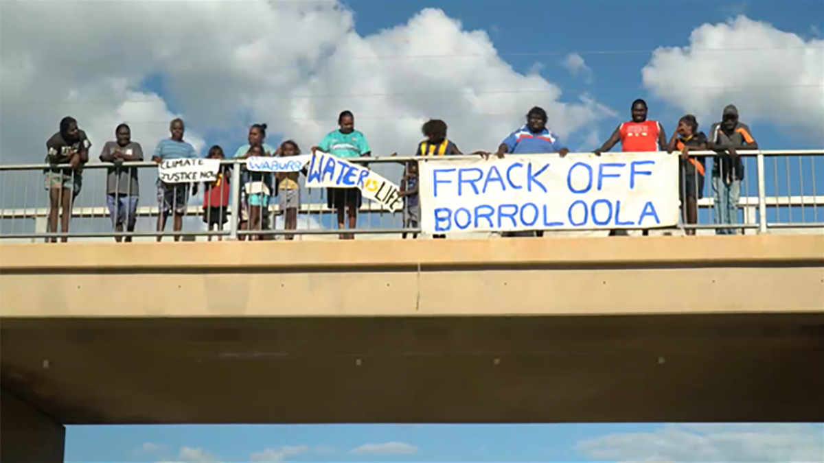 photo of people on a bridge with signs